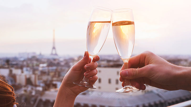 Two glasses of champagne or wine, couple in Paris, romantic celebration of engagement or anniversary
